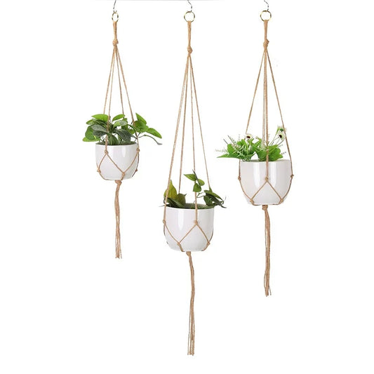 Set of three jute macrame plant hangers holding white pots
