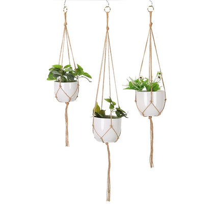 Set of 3 macrame plant hangers in natural jute-tone rope holding white pots, on a white background